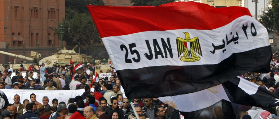 Egyptian flag with January 25, date uprising started, written on it, is seen amid crowd near army tanks in opposition stronghold of Tahrir Square, in Cairo
